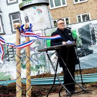 Rede vor Baustelle mit Plakaten im Hintergrund