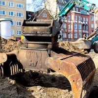 Bagger hebt Erde auf Baustelle
