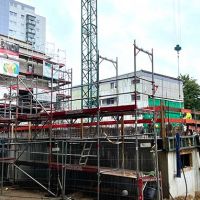 Baugerüst mit sichtbarem Gebäude und Bauarbeitern
