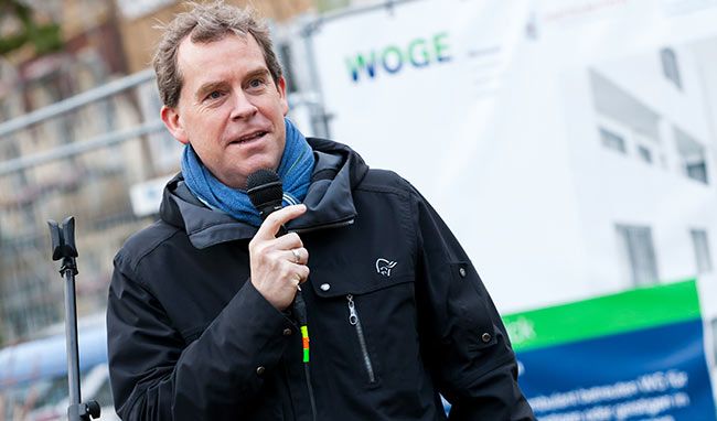Porträtfoto eines Mannes bei einer Rede vor der Baustelle