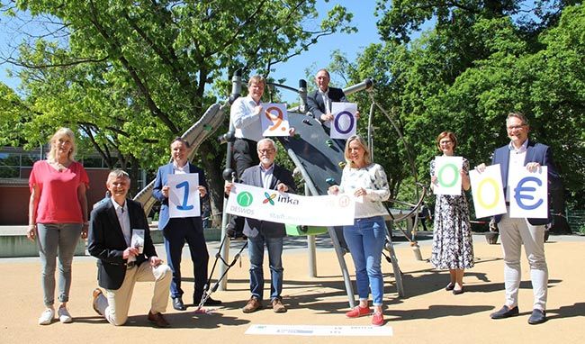 Gruppe von Menschen im Freien mit Banner zur Corona-Hilfe.