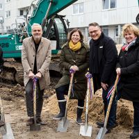 Menschen bei feierlichem Spatenstich