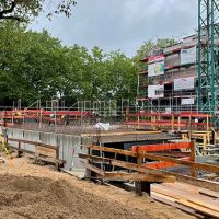Baugrube mit Betonarbeiten und Kran