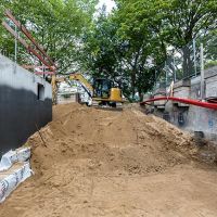 Bagger arbeitet mit Kies auf der Baustelle