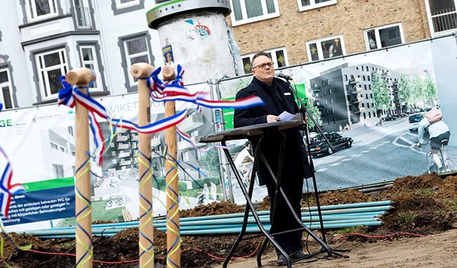 Rede vor Baustelle mit Plakaten im Hintergrund