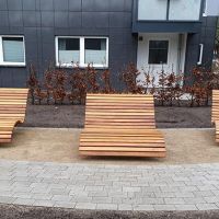 Mehrere Holzliegestühle am Wegrand
