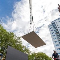 Kran hebt Betonplatte durch die Luft