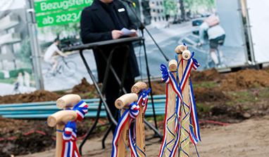 Redner hinter Sparten die im Sand stecken
