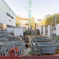 Baustelle mit Fundamentarbeiten und Gebäuden im Hintergrund