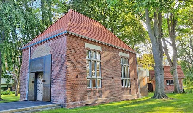 Historisches Backsteingebäude im Anscharpark Kiel, umgeben von Bäumen