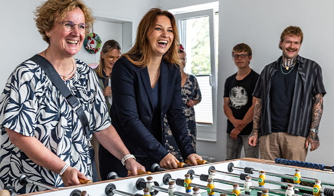 Innenministerin Magdalena Finke besucht den Wohnpark Wiker Quartier der WOGE in Kiel und spielt gemeinsam mit Mitarbeitern und Bewohnern Tischkicker.