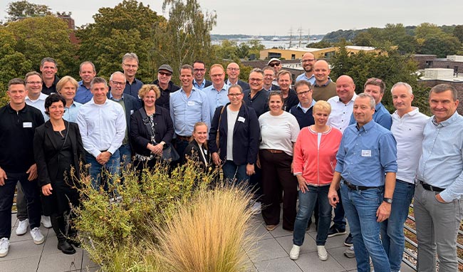 Gruppenfoto der Teilnehmenden der GäWoRing-Mitgliederversammlung auf einer Dachterrasse in Kiel